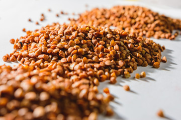 Grain buckwheat scattered on a white background, texture, hydrocarbon food