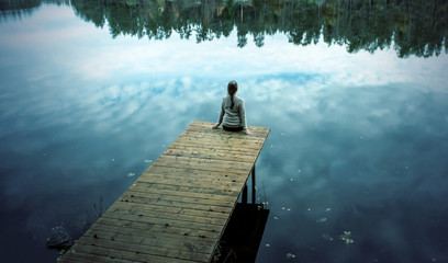 beautiful girl woman on the wooden bridge over lake in the autumn forest. River from a wooden bridge plenty calmness. The sunset scene evoques peace, relax time, reflection.