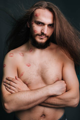 A young man with long hair. On a gray background.