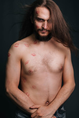 Naklejka premium A young man with long hair. On a gray background.