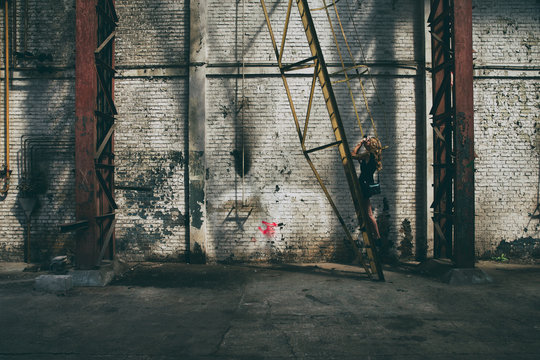 Photographer stands on a ladder in an abandoned building