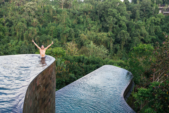 Man stands at the edge of an infinity pool