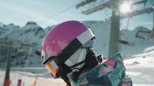 Follow shot of little girl heading off down ski slopes. View of ski lift in background.