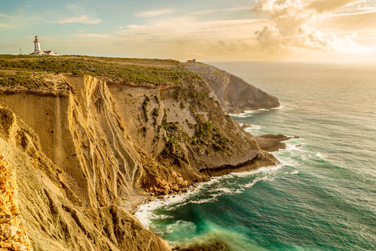 The Espichel Cape. Amazing view of lighthouse and seascape during golden hour. Atlantic Ocean during sunset