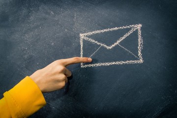 hand with mail envelope drawn on the blackboard