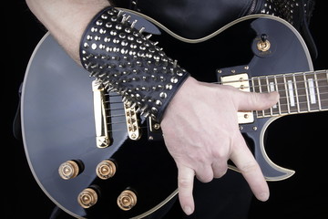 Guitarist.Closeup of electrical guitar fingerboard.Hand of rocker in leather  bracelet.Rock & roll,...