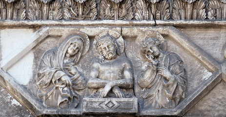 Jesus bound with the Virgin Mary and St. John on the portal of the Cathedral of S.Martino in Lucca, Italy