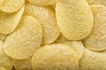 Potato chips on grey concrete table. Concept of fast food and snacks.
