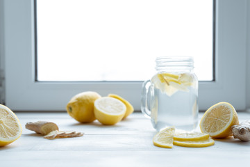 Lemon and a glass of ginger-lemon drink on the windowsill