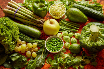 Fresh green vegetables and fruits assortment placed on a rusty metal