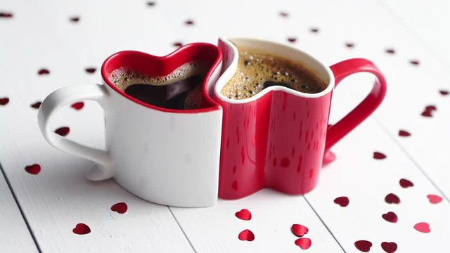 Two heart shaped coffee cups conected with each other.