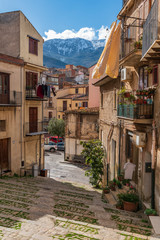 Fototapeta na wymiar Un vicolo della cittadina di Castelbuono con vista sulle cime innevate delle Madonie, provincia di Palermo IT 