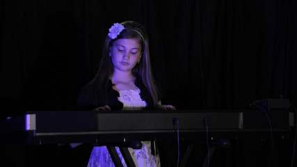 Young Girl playing Piano with Blue Accent Lights