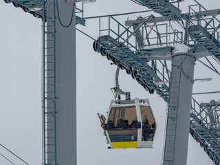 Extreme cable car ride. Winter holidays in the mountains. Snow-covered mountain slopes. Skiers and...