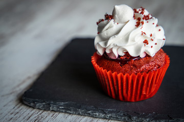 red cupcake with icing and sprinkles