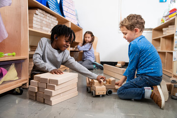 Students playing with wooden toys in classroom