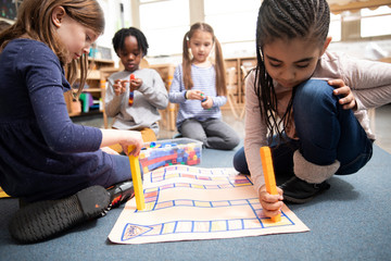 Students playing math game with plastic blocks