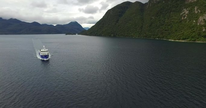 Aerial view with drone of a well-boat sailing through the channels of Chilean Patagonia