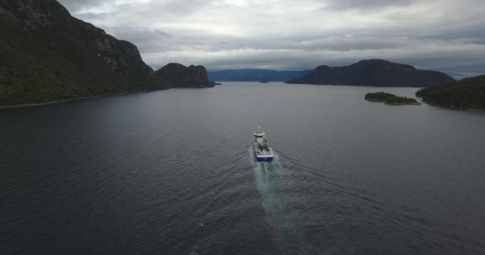 Aerial view with drone of a well-boat sailing through the channels of Chilean Patagonia