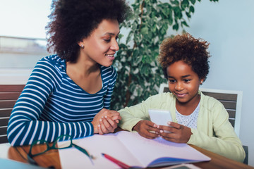 Mother and daughter doing homework learning to calculate