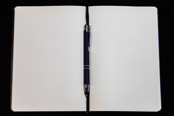 notebook and pen isolated on black background