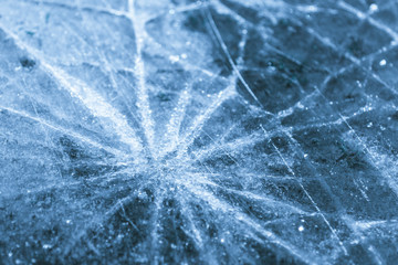 Close up of the ice of a clear frozen lake. Cracks in the ice close-up.