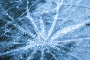 Cracks in the ice in the form of a star close-up. Winter background.