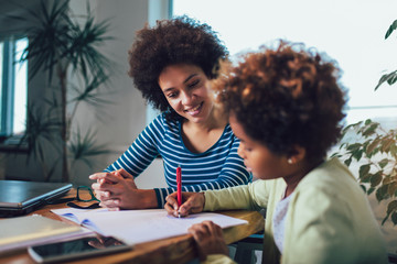 Mother and daughter doing homework learning to calculate - obrazy, fototapety, plakaty