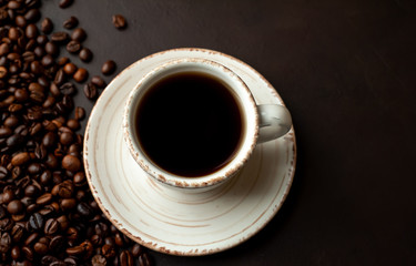 Coffee cup with roasted beans on stone background 