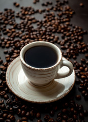 Coffee cup with roasted beans on stone background 