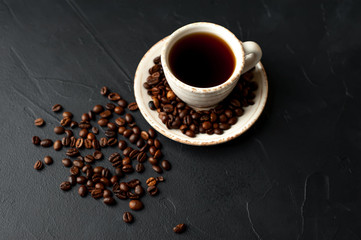 Obraz na płótnie Canvas Coffee cup with roasted beans on stone background 