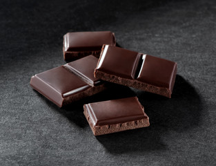 pieces of broken chocolate bar close-up  on gray background 