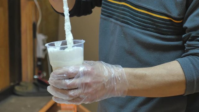 Male hands closeup. He mixes epoxy glue to make a boat.