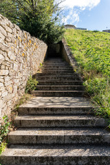 Fototapeta na wymiar Granite Stone stair in park. Steps going a long way up into a tunnel. Concept of Challenge or Climb to the success