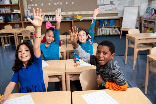 Students raising hands in class