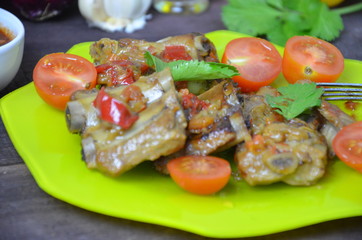 Pork ribs braised with soy sauce and vegetable tomato on the plate.