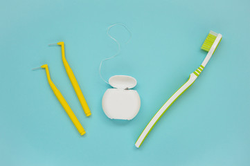 Teeth care, toothpaste, toothbrush and dental floss on blue background. Teeth cleaning brushing and...