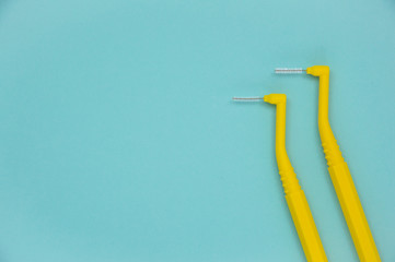 Teeth care, toothbrush and dental floss on blue background. Teeth cleaning brushing and flossing.