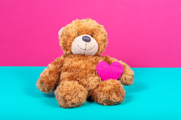 Teddy bear with felt heart on two color background