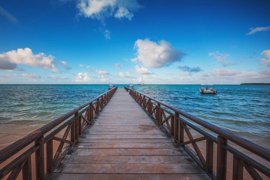 Wooden pier on a tropical island, clear sea and blue sky. Punta Cana, Dominican Republic