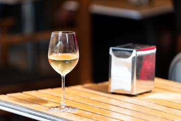 Orvieto, Italy Italian outdoor street in Umbria historic city town village with nobody and one glass filled with cold white wine in cafe restaurant