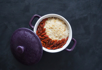 Oatmeal porridge with Goji berries on the black.