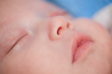 Close up photo of sleeping newborn baby face.