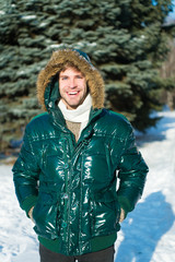 Winter outfit. Man unshaven wear warm jacket with fur snowy nature background. Guy wear winter...