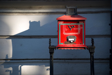 Red old-time post box against wall