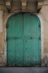Old weathered wooden turqoise painted garage door, Malta. Property renovation run down.