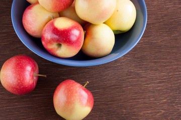 apples in a blue clay bowl on a wooden table