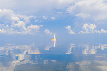 Obraz premium Sailboat in sea in sunny day on fabulous fairy tale picturesque seascape with clouds reflected in water. Luxury yacht summer adventure. Active vacation on mediterranean sea. Tourism and travel.