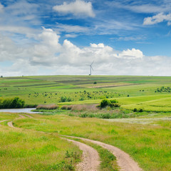 Hilly field and blue sky. Agricultural landscape.