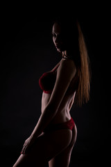 Woman in red lingerie in the shadows